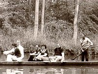 Schwarzweißbild von Personen in einem Boot auf dem Fluss.