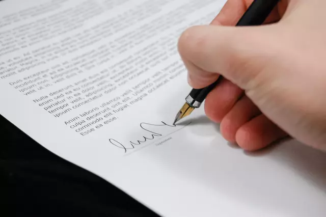 Hand mit Füller unterschreibt Dokument